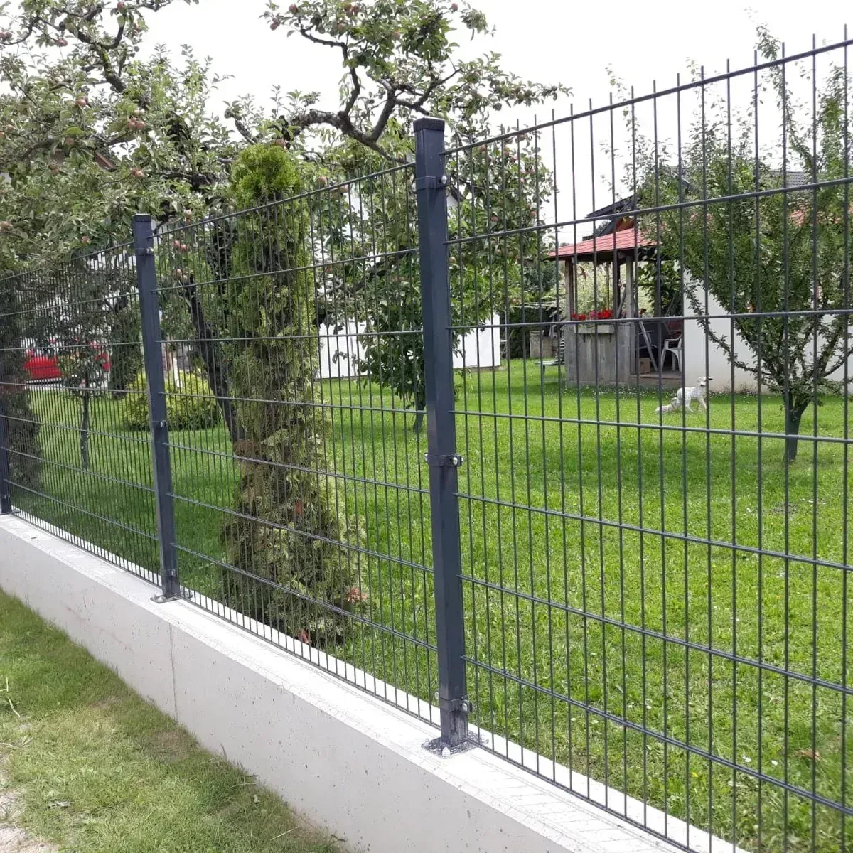 Antracit 2D dupla huzalos táblás kerítés beton lábazaton, kert mellett