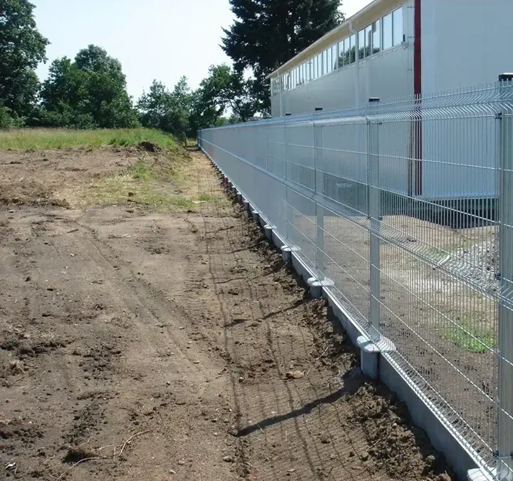 Horganyzott 3D táblás kerítés előre gyártott beton lábazati elemmel ipari csarnok mellett